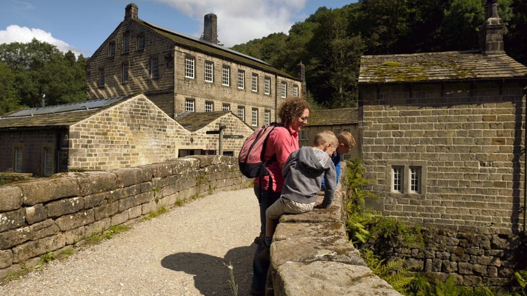 Visitors on a bridge at Hardcastle Crags with Gibson Mill in view, West Yorkshire